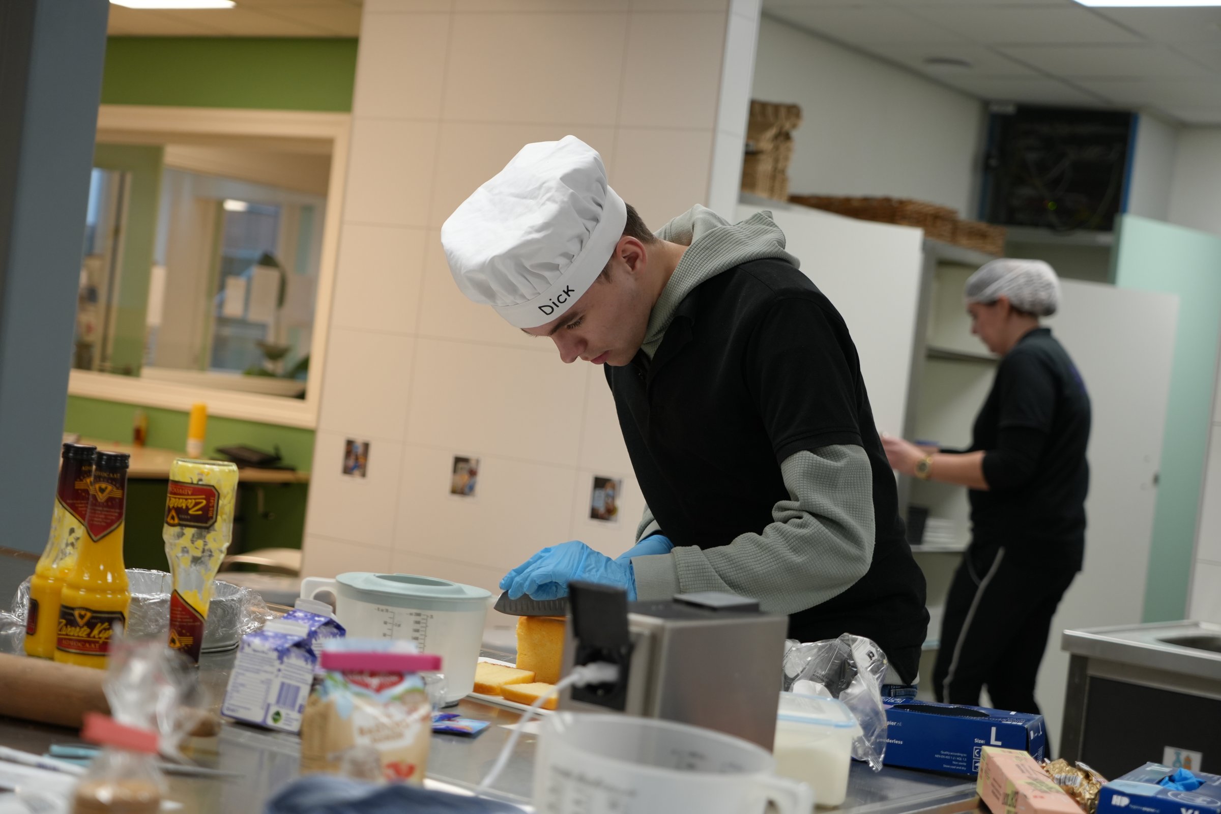 Deelnemers en begeleiders aan het werk in de keuken