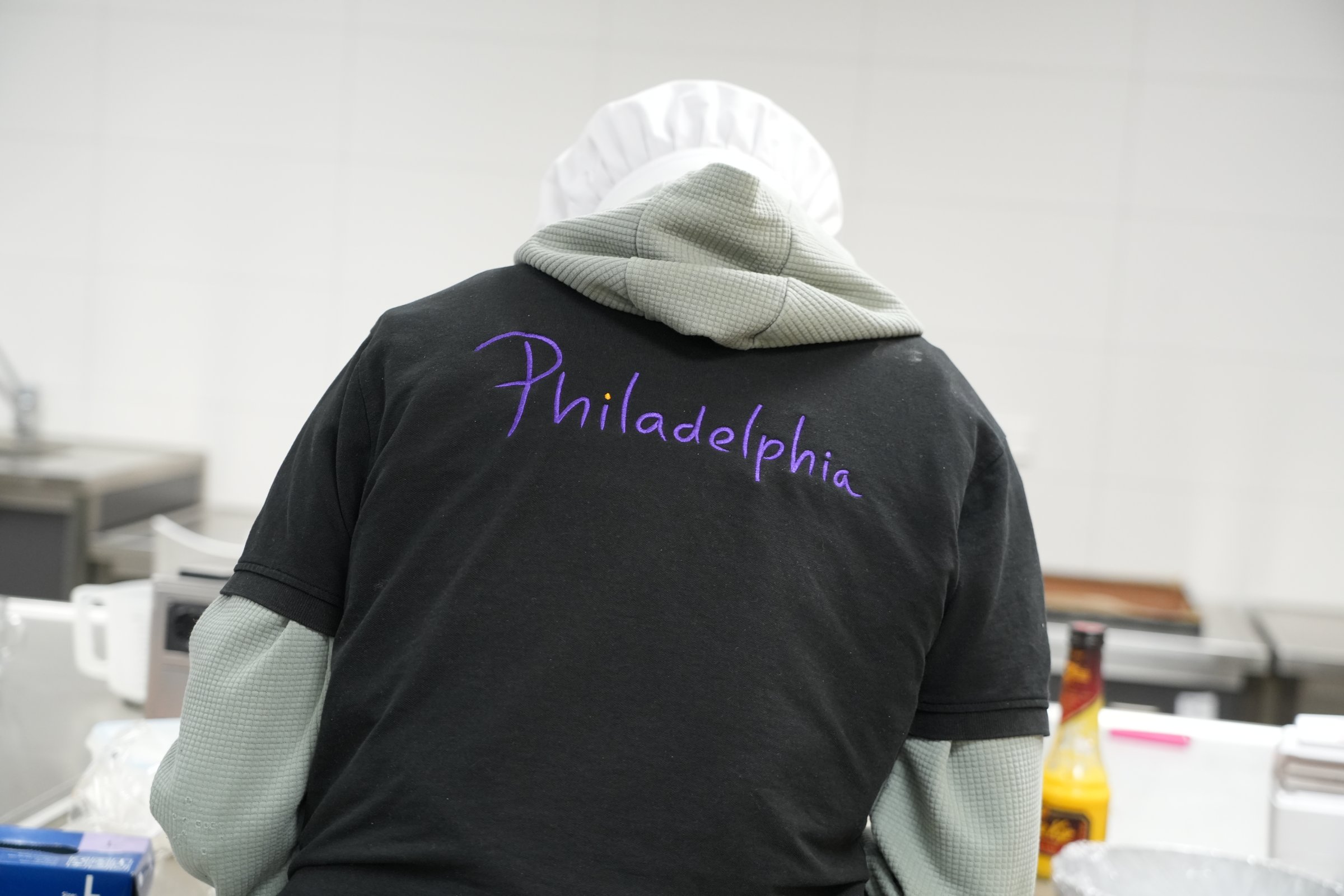 Deelnemer met Philadelphia-shirt aan het werk