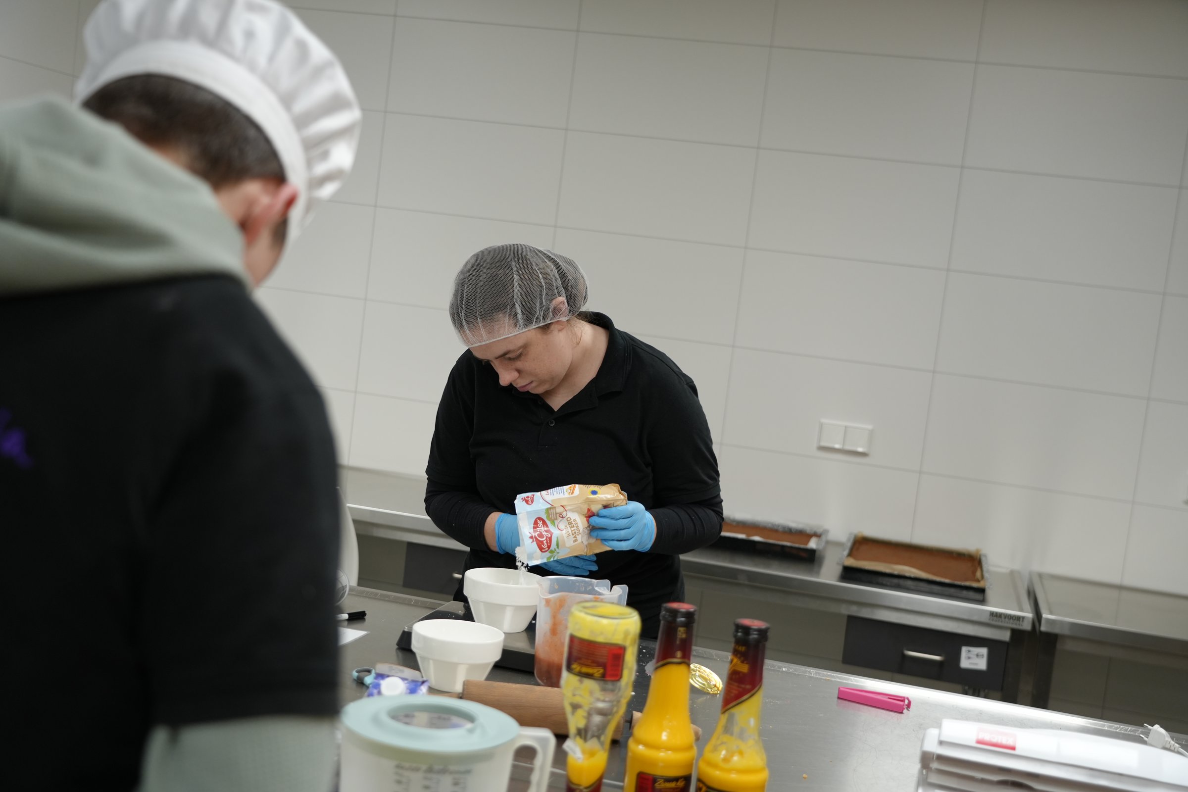 Deelnemer weegt basterdsuiker af tijdens het bakken